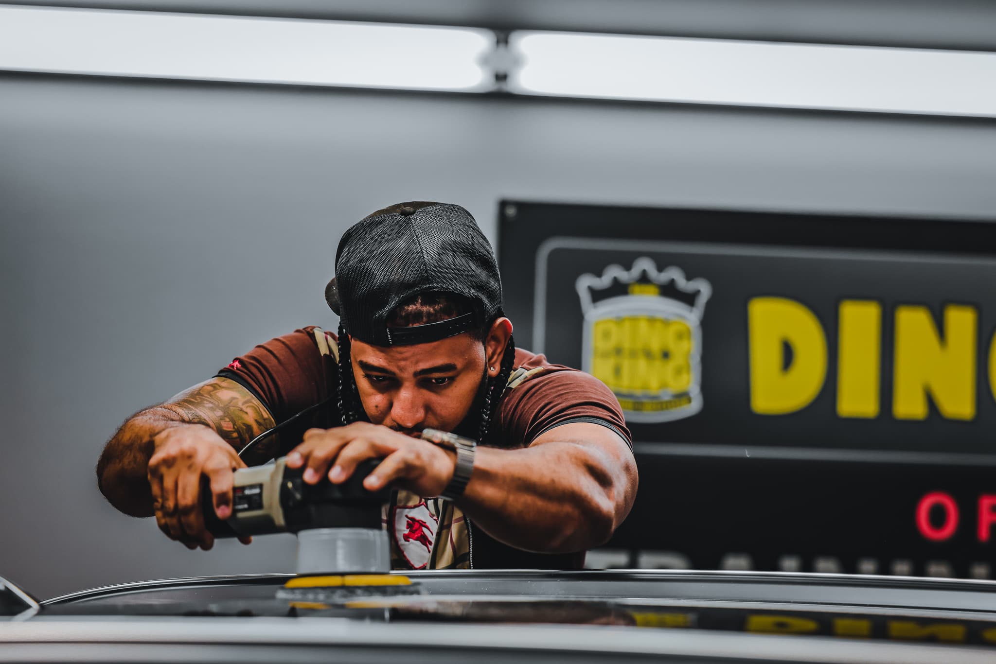 A technician machine-polishing a vehicle panel during paint correction training