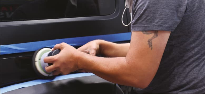 Machine polishing a vehicle panel during hands-on paint correction training
